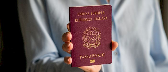 woman_holding_an_italian_passport_original_2898447.700x300.jpg